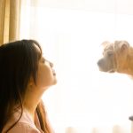 woman in white shirt beside white short coated dog